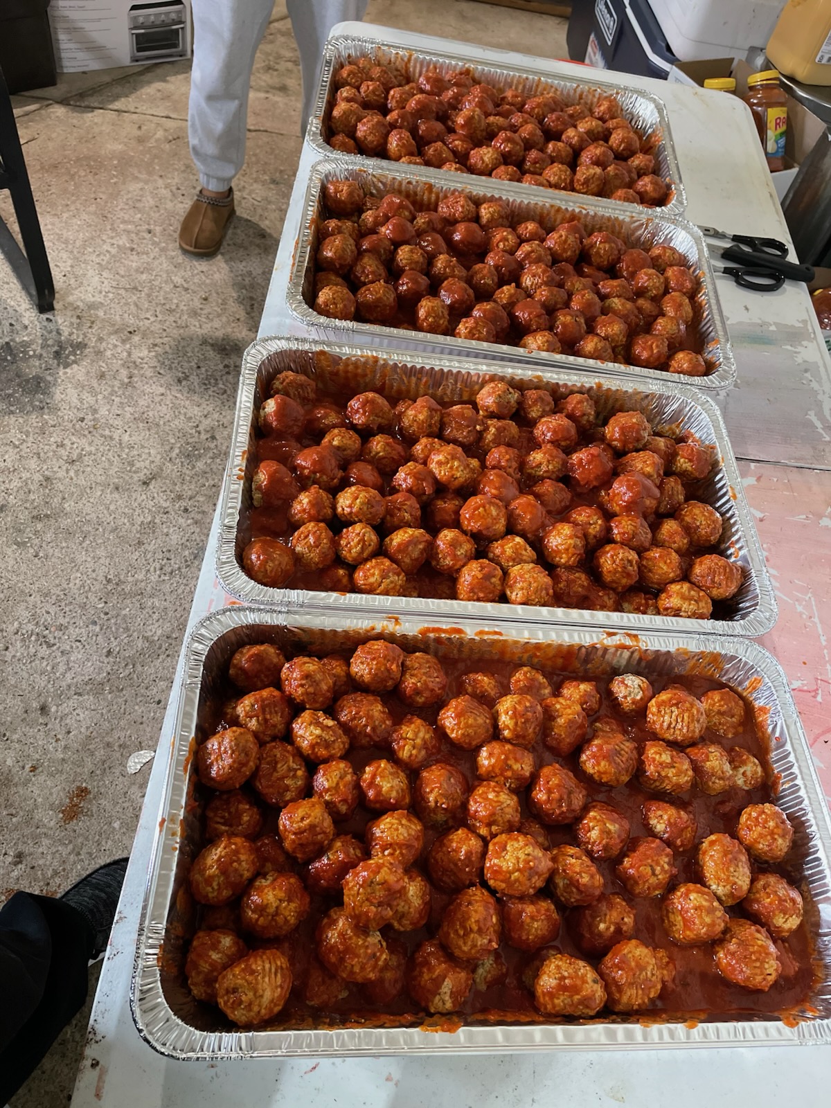 Italian meatballs in red sauce by the tray